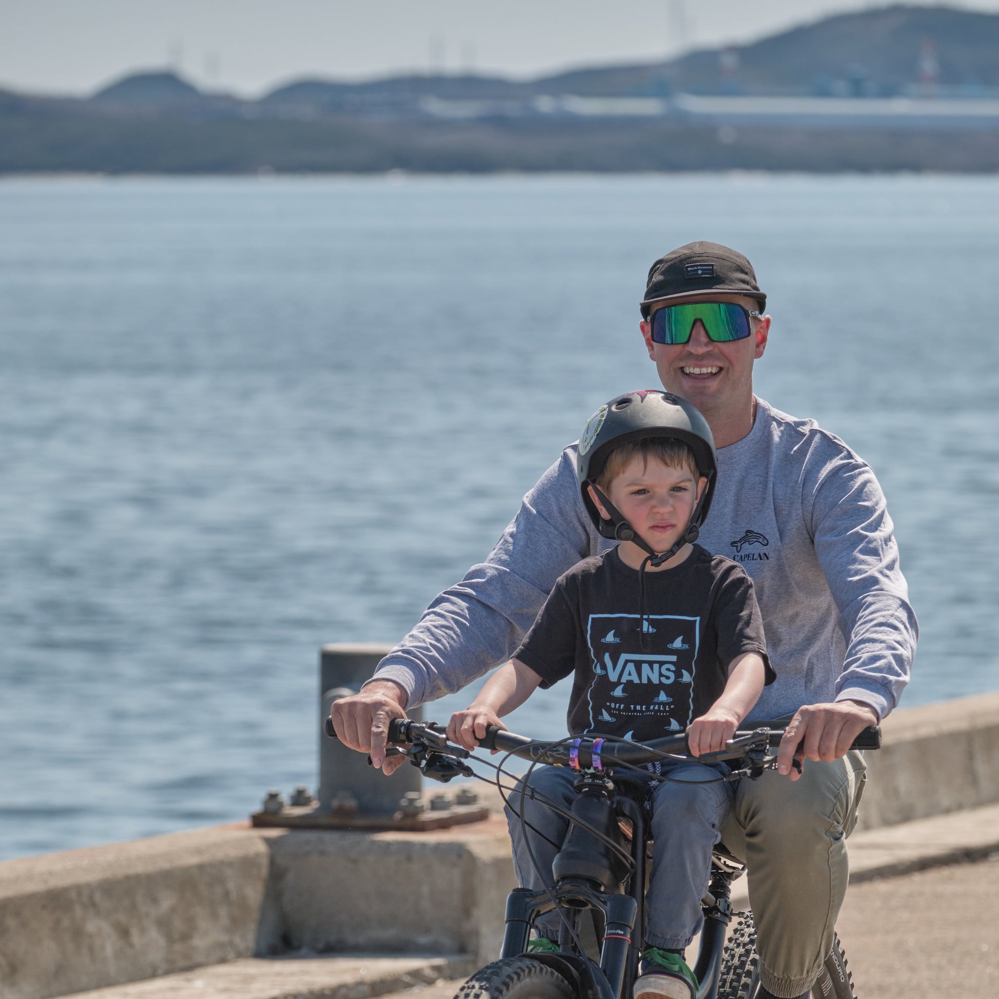 Homme en vélo avec son fils, sur un quai à Sept-Îles